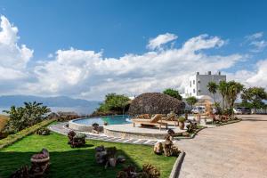 a resort with a pool and a view of the water at Fuxian Lake Lanshan Su Ant Nest Homestay in Xujiadu