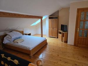 a bedroom with a bed and a wooden floor at ТСЦ Тисовець in Tysovets