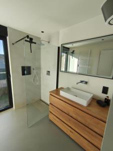 een badkamer met wastafel en douche met spiegel bij Modern spatious house near Bruges in Brugge