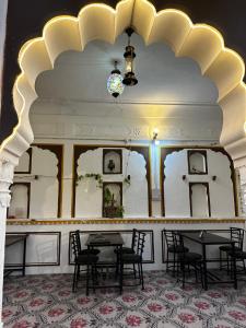 ein Esszimmer mit Tischen und Stühlen und einer Decke in der Unterkunft Hotel Kota kunj Heritage in Pushkar
