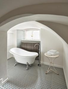 a white bath tub in a bathroom with a window at Zámek Žďár in Žďár nad Sázavou