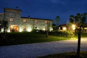 a large stone building with a yard at night at Sarzana-Charming Apartment Pool and BB in Sarzana