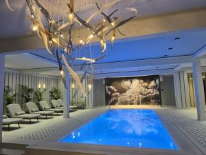 une piscine dans un hall avec des chaises et un tableau dans l'établissement Dwór Prezydencki Boutique Hotel & SPA, à Tarnów