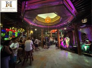 a crowd of people in a bar with a purple ceiling at M'pai Bay Hotel in Koh Rong Sanloem