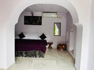 Schlafzimmer mit einem Bett in Bogenrichtung in der Unterkunft Hotel Kota kunj Heritage in Pushkar