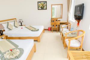 a hotel room with two beds and a television at Viet Thai Hotel in Hồng Lĩnh