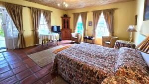 a bedroom with a bed and a table and windows at Villa Rosa in Ladismith