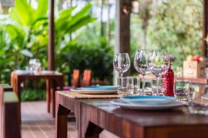 - une table en bois avec des verres à vin et des assiettes dans l'établissement Orchard Pa La U, à Ban Pa Lau