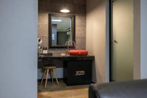 a bathroom with a sink and a mirror and a stool at XYM Hotel Icheon in Icheon