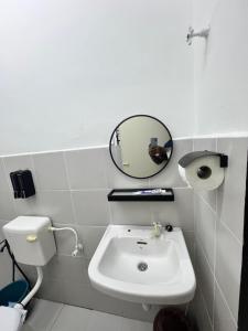 a white bathroom with a sink and a mirror at Coach homestay in Kuantan +23 photos