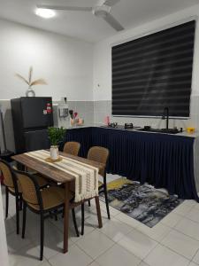 a kitchen with a table with chairs and a blue curtain at Coach homestay in Kuantan