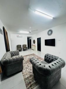a living room with two couches and a flat screen tv at Coach homestay in Kuantan