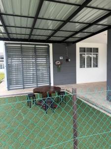 a patio with a wooden table in the grass at Coach homestay in Kuantan