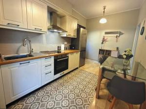 - une cuisine avec des placards blancs, un évier et une table dans l'établissement Centrally located, à Gaios