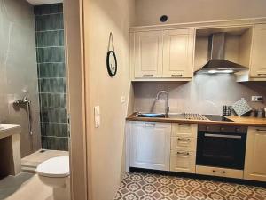 une cuisine avec des armoires blanches, un évier et des toilettes dans l'établissement Centrally located, à Gaios