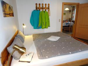 een slaapkamer met een bed en een lamp op een tafel bij Bärli in Bayersoien