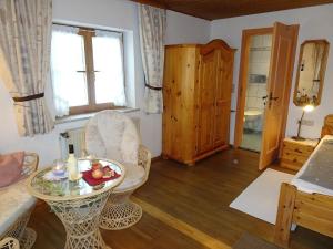 een woonkamer met een tafel en een stoel bij Bärli in Bayersoien +19 foto's