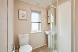a bathroom with a toilet and a sink at Kinship Lodge with Hot Tub in York +19 photos