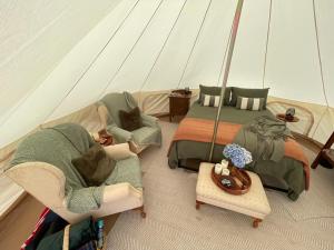 a room with two chairs and a bed in a tent at Fairy Wren Off Grid Luxury Glamping Retreat in Wine Country in Lilydale