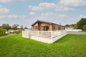 a small house on a green field with a house at Kinship Lodge with Hot Tub in York