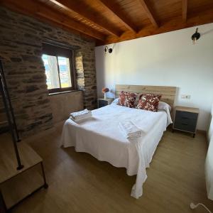 ein Schlafzimmer mit einem großen weißen Bett und Kissen in der Unterkunft A Barreira in Ferrol