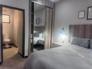 a bedroom with a large bed and a mirror at Zango Apartments in Shikalenge