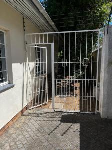 a gate to a house with a dog inside at Central Eclectic Studio by ARPA Hospitalities in Stellenbosch