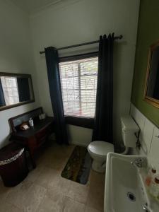 a bathroom with a toilet and a window and a sink at Central Eclectic Studio by ARPA Hospitalities in Stellenbosch