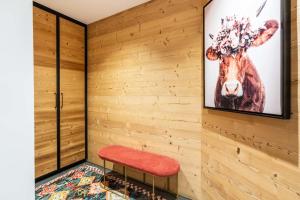een kamer met een rode bank en een afbeelding van een koe bij Chalet Grand Lac in Chandon