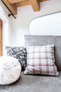 een kussen op een bank met een geruit kussen bij Chalet Grand Lac in Chandon