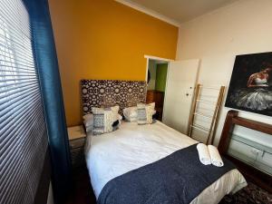 a small bedroom with a bed and a mirror at Central Eclectic Studio by ARPA Hospitalities in Stellenbosch
