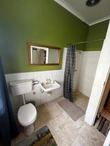 a bathroom with a toilet and a sink and a mirror at Central Eclectic Studio by ARPA Hospitalities in Stellenbosch