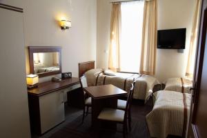 a hotel room with a bed and a table and a room at Sanatorium Podhale in Połczyn-Zdrój