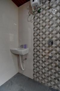 Un baño con lavabo y ducha en Hotel krishna Regency, en Dāpuri