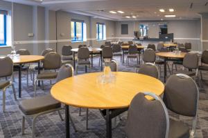 a conference room with tables and chairs and a podium at Holiday Inn Express Birmingham Airport NEC by IHG in Bickenhill