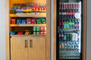 a refrigerator filled with lots of sodas and drinks at Holiday Inn Express Birmingham Airport NEC by IHG in Bickenhill +124 photos