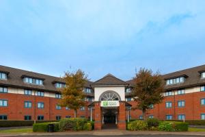 a large red brick building with a building at Holiday Inn Express Birmingham Airport NEC by IHG in Bickenhill