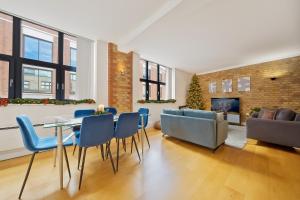 a living room with a table and chairs and a fireplace at Spitalfields Sanctuary 2 Bed 2 Bath 100sqm Aprt in London