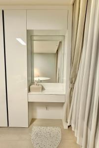ein Badezimmer mit Waschbecken und Spiegel in der Unterkunft Shine Stay 5 Min from Songdo Moonlit Festiv Park Station in Taeam