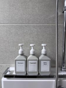 vier Flaschen Waschmittel auf einem Regal in einem Badezimmer in der Unterkunft Shine Stay 5 Min from Songdo Moonlit Festiv Park Station in Taeam + 14 Fotos