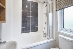 ein Badezimmer mit Badewanne und Toilette und einem Fenster in der Unterkunft The Flamingo Lodge with Hot Tub in York + 24 Fotos