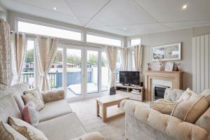 ein Wohnzimmer mit zwei Sofas und einem Fernseher in der Unterkunft The Flamingo Lodge with Hot Tub in York