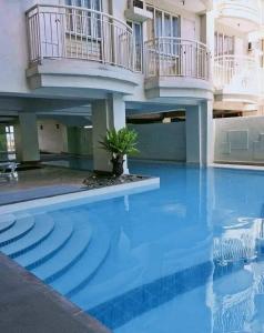 ein Gebäude mit einem Pool mit einem Haus in der Unterkunft Tagaytay Condo Staycation- Taal-view with balcony in Iruhin