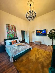 ein Schlafzimmer mit einem Bett und einem Kronleuchter in der Unterkunft Premium-Apartment im Duisburger Süden, nähe Düsseldorf Flughafen & Messe, Komplett ausgestattetes Apartment mit modernen Altbau-Flair in Duisburg