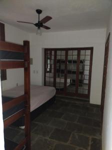 une chambre avec un lit superposé et un ventilateur de plafond dans l'établissement Suite na mansão Ilhabela, à Ilhabela