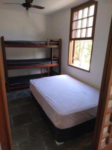 une chambre avec deux lits superposés et une fenêtre dans l'établissement Suite na mansão Ilhabela, à Ilhabela
