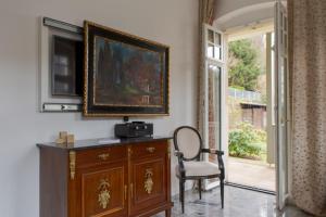 a room with a wooden cabinet and a chair and a picture at Villa Elbufer in Bad Schandau