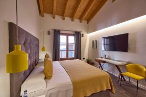 パルマ・デ・マヨルカにあるHotel Bosch Boutiqueのベッドと机とテレビのある寝室