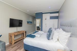 Un dormitorio con una cama con un televisor en la pared. en Brookes at Sea, en Gqeberha 15 fotos más