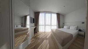 a hotel room with a large bed and a window at Metro Hotel Terminal in Tirana